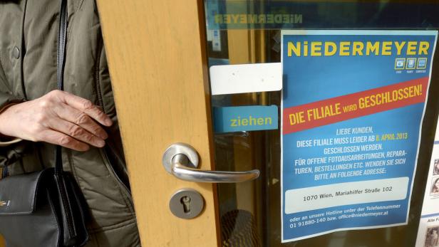 Eine Person steht vor der Tür eines Niedermeyer-Geschäfts, das geschlossen wird.