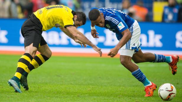 Zwei Fußballspieler kämpfen um den Ball auf dem Spielfeld.