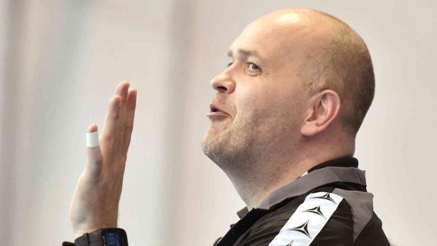 Ein Mann mit erhobener Hand, möglicherweise ein Trainer oder Schiedsrichter.