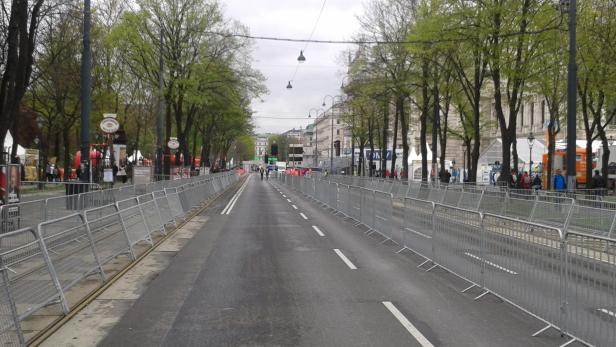 Eine leere Straße in Wien ist mit Absperrgittern gesäumt.