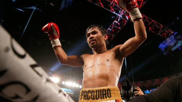 Manny Pacquiao feiert mit erhobenen Armen und Boxhandschuhen seinen Sieg.
