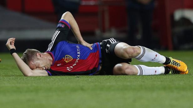 Ein Fußballspieler liegt verletzt auf dem Rasen und krümmt sich vor Schmerzen.