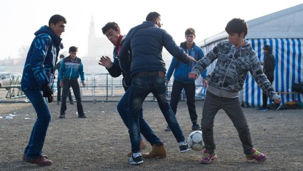 Flüchtlinge spielen an einer Versorgungsstation Fußball. (Oktober 2015)