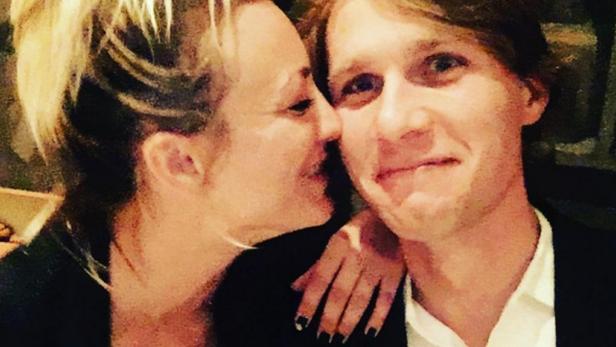 Eine Frau umarmt einen Mann, beide lächeln.