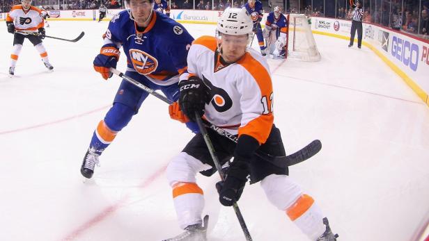 Zwei Eishockeyspieler kämpfen auf dem Eis um den Puck.