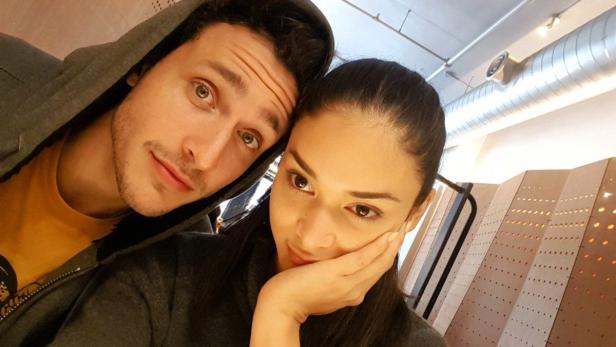 Ein Mann mit Kapuze und eine Frau machen ein Selfie.