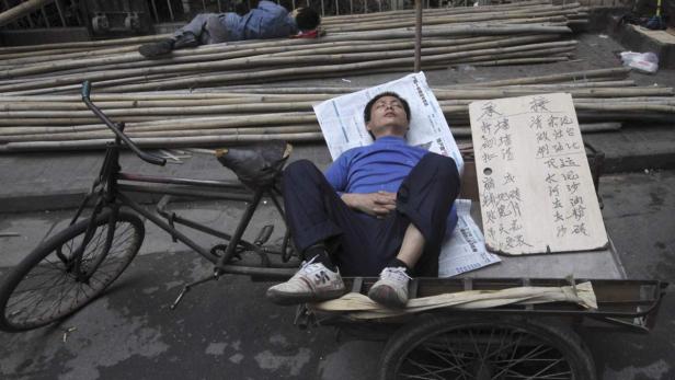 Ein chinesischer Wanderarbeiter auf der Suche nach einem Job – per Stellengesuch am Pappschild. Leute wie er sollen im Reich der Mitte künftig mehr Rechte genießen