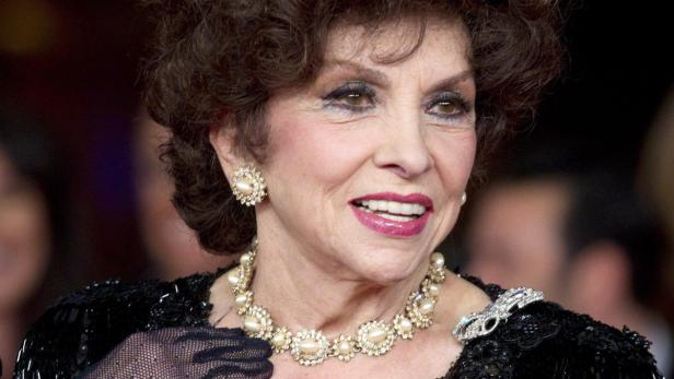 Gina Lollobrigida lächelt mit Perlenkette und Ohrringen.