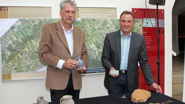 Landesrat Helmut Bieler und Archäologe Kurt Fiebig präsentieren den Sensationsfund, der bei Grabungsarbeiten an der B61a entdeckt wurde