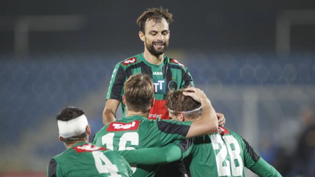 Fußballspieler wird von seinen Teamkollegen umarmt.