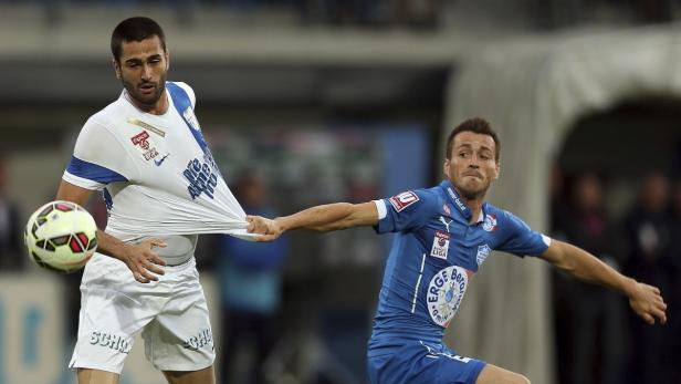 Ein Fußballspieler zieht am Trikot seines Gegners.