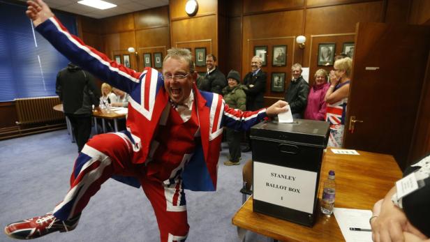 epa03618448 A man wearing a Union flag suit dances as casts his vote in the referendum to decide if Falkland Islands remains as British territory in Port Stanley, Falkland Islands, 10 March 2013. Reports state that the islanders decided to hold the referendum in response to Argentine pressure for negotiations over sovereignty. EPA/JAVIER LIZON