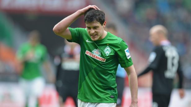 Ein Fußballspieler von Werder Bremen greift sich an den Kopf.