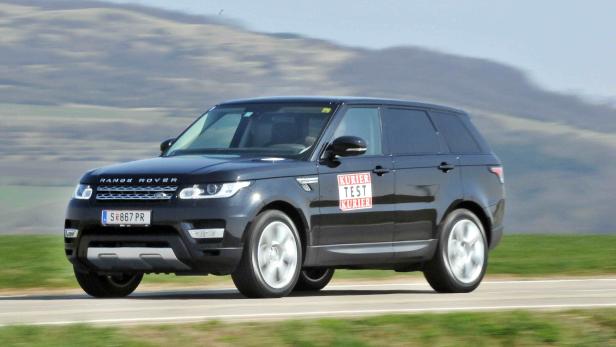 Ein schwarzer Range Rover fährt auf einer Landstraße.