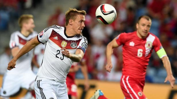 Ein deutscher Fußballspieler köpft den Ball während eines Spiels.