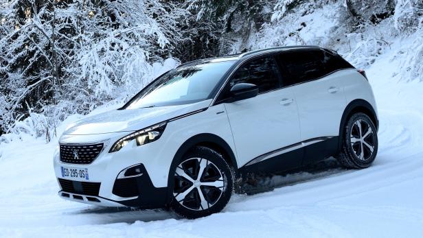 Ein weißer Peugeot 3008 fährt auf einer schneebedeckten Straße.