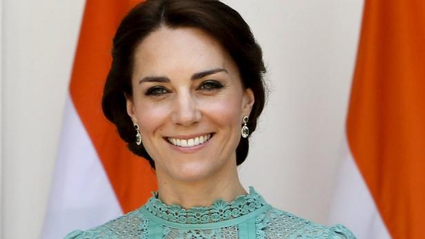 Catherine, Princess of Wales, lächelt vor einer Flagge.