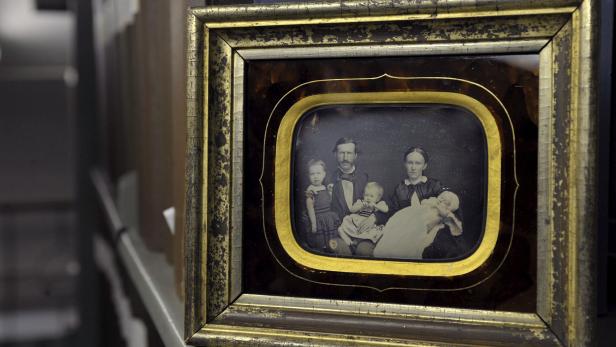 Ein gerahmtes, historisches Familienporträt mit Eltern und drei kleinen Kindern.