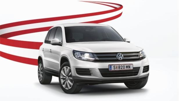 Ein weißer VW Tiguan vor einem Hintergrund mit österreichischen Farben.
