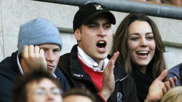 Prinz Harry, Prinz William und Catherine, Prinzessin von Wales, schauen bei einer Sportveranstaltung zu.