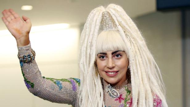 Singer Lady Gaga waves upon her arrival at Narita