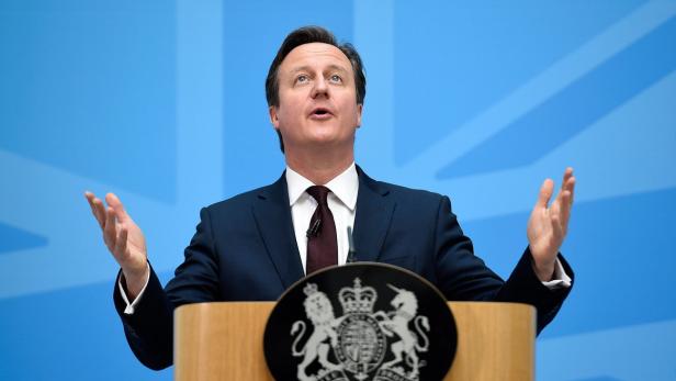 David Cameron hält eine Rede vor einem blauen Hintergrund.