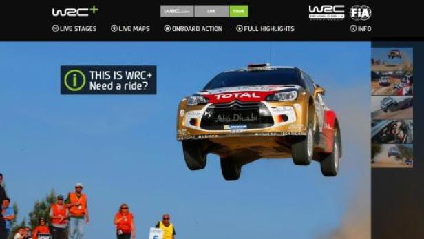 Ein Rallyeauto springt über eine Anhöhe in die Luft.