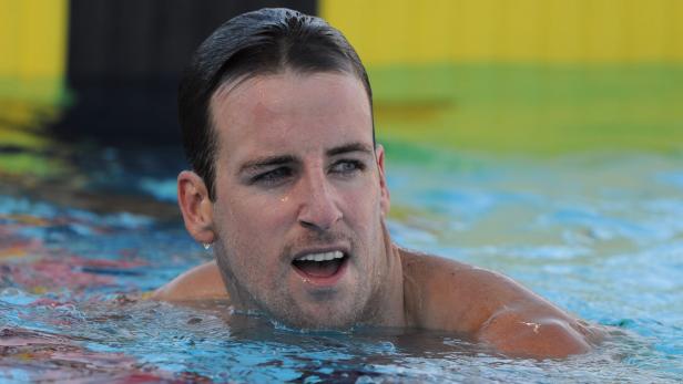 Ein Mann schwimmt im Wasser und schaut zur Seite.