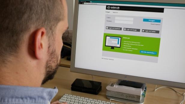 Ein Mann meldet sich auf der Webseite golem.de an.