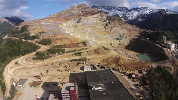 Luftaufnahme eines Tagebaus in einer bergigen Landschaft.