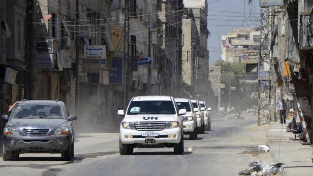A convoy of U.N. vehicles carrying a team of United Nations chemical weapons experts and escorted by Free Syrian Army fighters (vehicle on left) drive through one of the sites of an alleged chemical weapons attack in eastern Ghouta in Damascus suburbs August 28, 2013. A team of United Nations inspectors reached rebel-held territory outside Damascus on Wednesday, opposition activists said, and would soon begin a second day of investigating the sites of an alleged chemical weapons attack that killed hundreds of people. REUTERS/Bassam Khabieh (SYRIA - Tags: POLITICS CIVIL UNREST TPX IMAGES OF THE DAY CONFLICT)