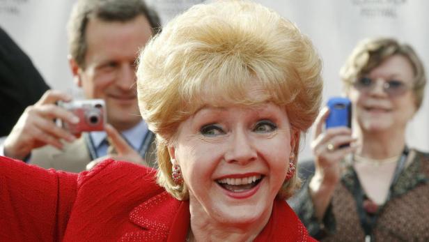 Actress Reynolds is photographed by fans as she ar