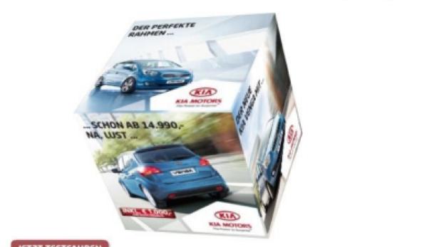Ein Würfel zeigt Werbung für den Kia Venga mit dem Slogan „Der perfekte Rahmen…“.