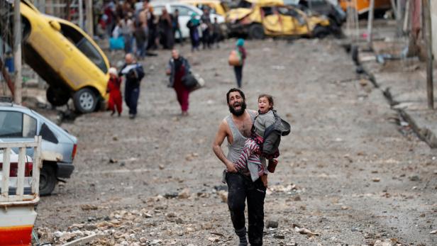 Ein Mann flüchtet mit seiner Tochter aus dem vom IS kontrollierten Stadtteil.