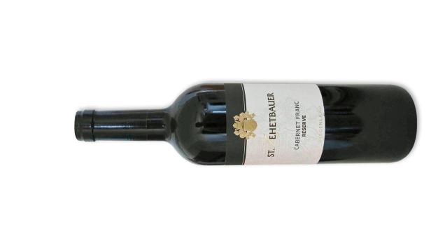 Eine Flasche St. Ehebauer Cabernet Franc Reserve Burgenland liegt auf der Seite.