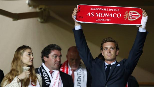 Ein Mann hält einen Schal des AS Monaco hoch.