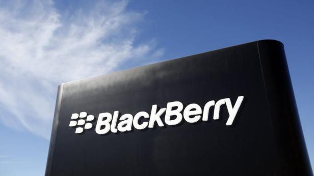 Das BlackBerry-Logo auf einem schwarzen Schild vor blauem Himmel.