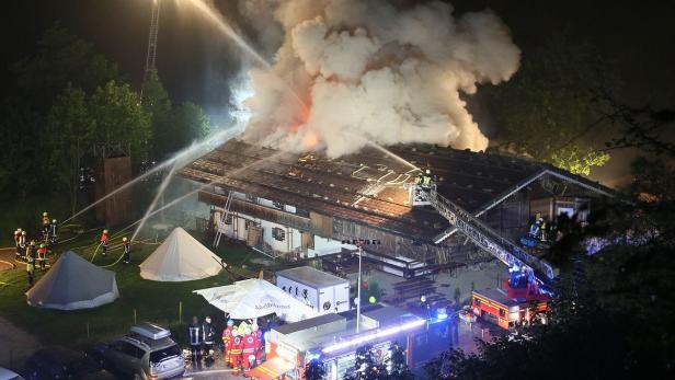 Ein brennendes Gebäude wird von Feuerwehrleuten gelöscht.