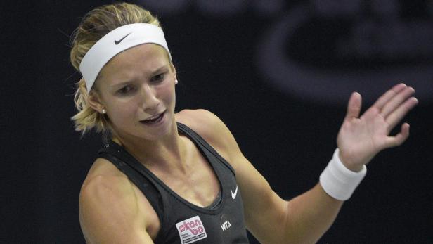 Eine Tennisspielerin mit einem Nike-Stirnband winkt während eines Spiels.