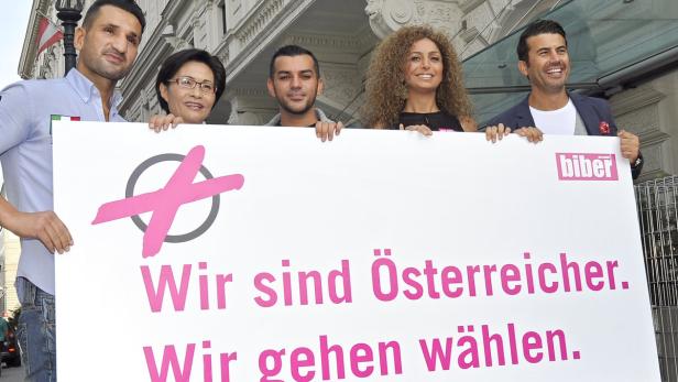 Eine Gruppe von Menschen hält ein Schild mit der Aufschrift „Wir sind Österreicher. Wir gehen wählen.“.