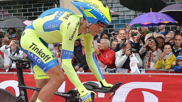 Ein Radrennfahrer des Teams Tinkoff-Saxo fährt ein Rennen, während Zuschauer am Straßenrand applaudieren.
