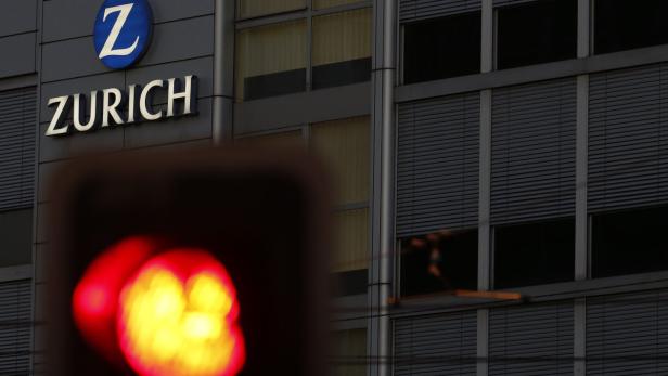 The logo of Swiss insurance group Zurich is seen behind a red traffic light on a building in Bern August 15, 2013. Zurich Insurance Group cautioned that it would be challenged to meet certain performance targets after posting a 27 percent fall in second-quarter net profit due to natural disaster payouts. REUTERS/Ruben Sprich (SWITZERLAND - Tags: BUSINESS LOGO)