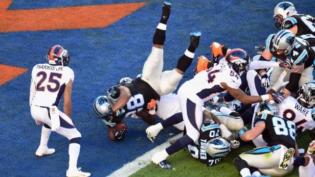 Ein Footballspieler wird während eines Spiels von mehreren Gegenspielern zu Fall gebracht.