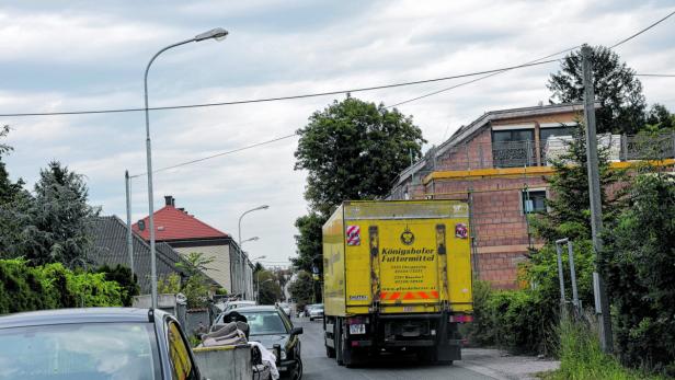 Die Lkw müssen sich durch die enge Zufahrtsstraße, vorbei an Wohnhäusern, zwängen.