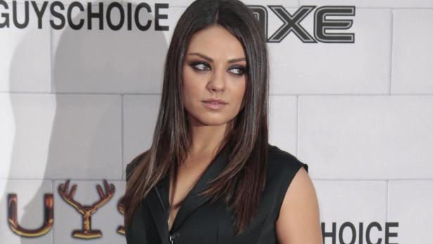 Mila Kunis posiert vor einem Hintergrund mit den Logos „Guys Choice“ und „Axe“.