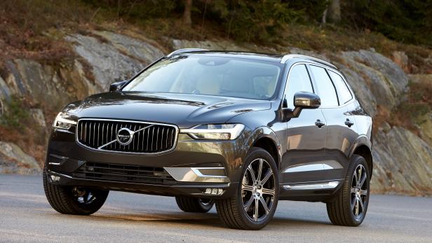 Ein dunkelgrauer Volvo XC60 steht auf einer asphaltierten Straße.
