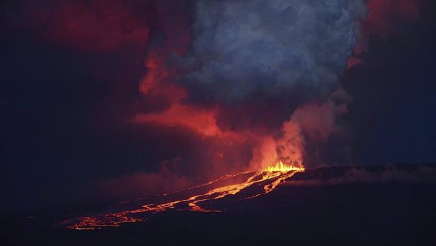 Ein Vulkan bricht aus und Lava fließt den Hang hinunter, während Rauch aufsteigt.