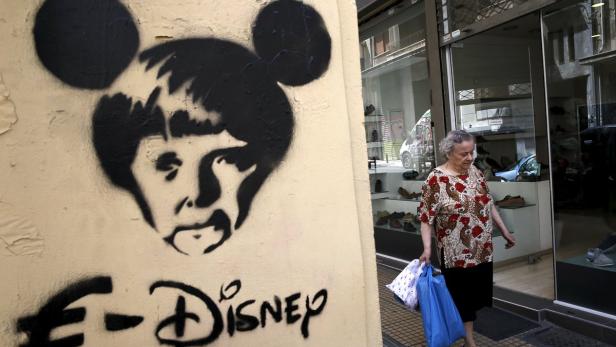 Eine ältere Frau geht an einem Graffiti vorbei, das eine Mickey-Mouse-ähnliche Figur zeigt.