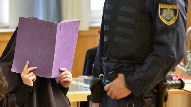 Eine verschleierte Frau liest eine lila Akte neben einem Justizbeamten.