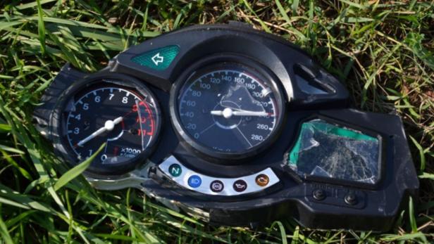Ein beschädigtes Motorrad-Cockpit liegt im Gras.